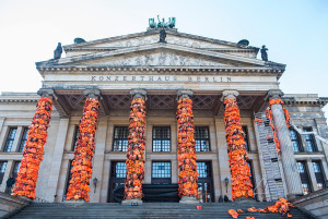 Assistants of Chinese artist Ai Wei Wei decorate the columns of Berlin's Konzerthaus with lifejackets, on February 13, 2016, as part of an installation intended to remind people of the ongoing refugee crisis.  The Cinema for Peace gala will be held at the Konzerthaus on February 15, 2016, on the sidelines of the Berlinale Film Festival. / AFP / John MACDOUGALL        (Photo credit should read JOHN MACDOUGALL/AFP/Getty Images)