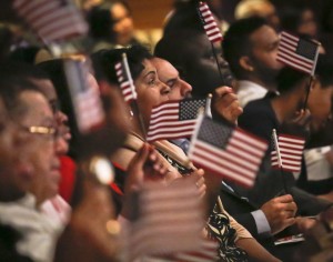 New U.S. citizens wave flags during a special Flag Day naturalization ceremony at the New York Historical Society, Tuesday, June 14, 2016, in New York. U.S. Citizenship and Immigration Services (USCIS) naturalized 200 immigrants from from 37 countries at the museum, followed by the unveiling of "The Fourth of July, 1916", the oil painting by American impressionist artist Childe Hassam, depicting Fifth Avenue covered with American flags for Independence Day. (AP Photo/Bebeto Matthews)
